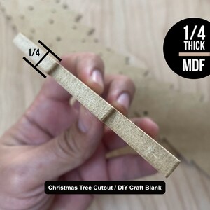 May include: A close-up of a 1/4 inch thick MDF Christmas tree cutout. The cutout is unfinished and ready to be painted or decorated. The text "Christmas Tree Cutout / DIY Craft Blank" is printed below the cutout.