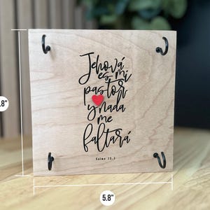 May include: A wooden sign with a red heart and the text "Jehov&aacute; es mi pastor y nada me faltar&aacute;" in black lettering. The sign is 5.8 inches wide and 5.8 inches tall. The text is from Psalm 23:1.