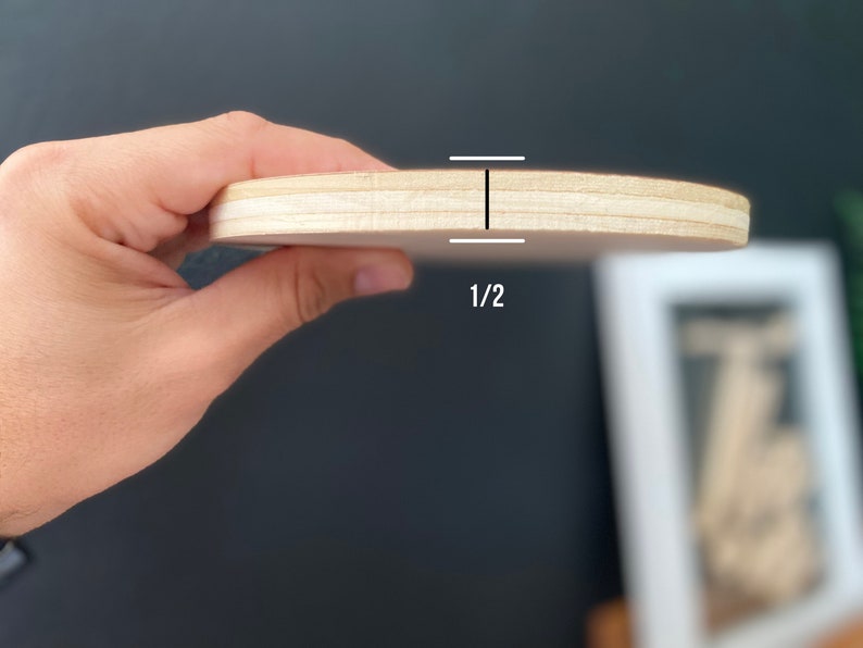 May include: A close-up of a round wooden plaque, showing the thickness of the wood, which is 1/2 inch.