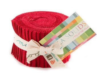 May include: A roll of red fabric with a white ribbon and a tag that says "Moda Solids moda".