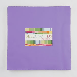 May include: A purple fabric square with a Bella Solids Moda label in the center. The label has a colorful geometric pattern.