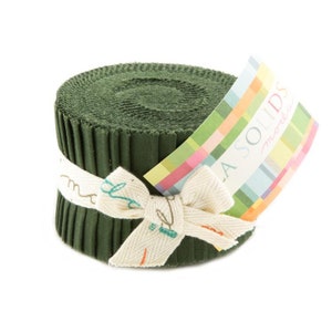 May include: A roll of dark green fabric with a white ribbon tied around it. The label reads "Moda Solids" in a colorful font.