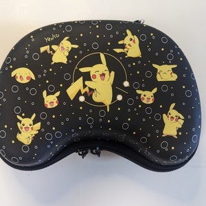 May include: Black carrying case with a zipper closure and a repeating pattern of yellow Pikachu characters on a black background. The case has the word "Yeehe" printed on the top.
