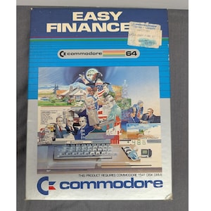 May include: A rectangular software box for the Commodore 64 titled Easy Finance. The blue and white packaging features a colourful illustration of people in business settings, a computer keyboard, and the text This product requires Commodore 1541 disk drive.