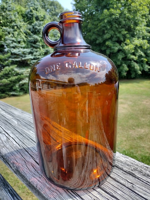 c. 1920's original dark amber colored american industrial oversized one  gallon glass laboratory screw top jug with integrated circular-shaped handle