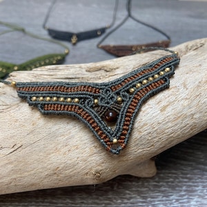 May include: A brown and gray macrame necklace with gold beads and a brown stone pendant.