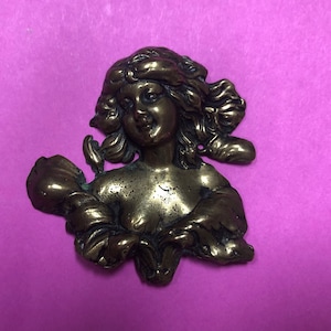 Könnte beinhalten: Eine Bronzeskulptur eines Frauenbüste mit einem floralen Design. Die Skulptur ist detailliert und hat ein realistisches Aussehen.