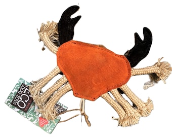 May include: A tan and orange rope dog toy shaped like a crab. The crab has a suede body and black felt claws. The toy is labeled "ECO Dog Toys Natural Yellow  Cottons".