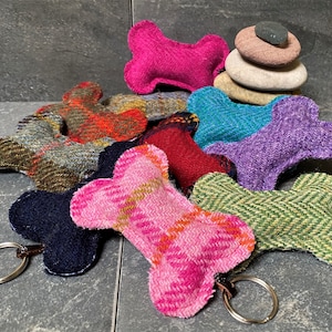 Peut inclure: Assortiment de jouets en forme d'os de chien de différentes couleurs en tissu tweed. Les jouets sont de différentes couleurs, notamment rose, bleu, vert, rouge et violet. Certains jouets sont munis d'un porte-clés.