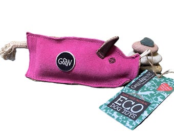 May include: Pink suede dog toy with a rope tail and a brown leather ear. The toy is filled with stones and has a G&W logo on the front. The toy is packaged with a green and white label that says "Green & Wilds" and "Eco Dog Toys".