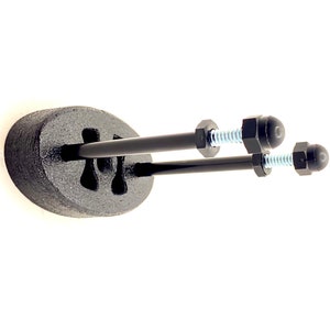 May include: Two black metal rods with threaded ends and black plastic caps are mounted to a black oval base. The rods are secured with silver nuts.