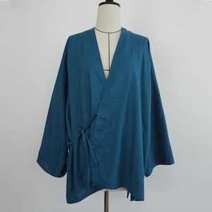 May include: A teal-colored kimono-style wrap top with long sleeves and a tie closure at the waist. The garment is displayed on a mannequin against a plain white background. The fabric appears to be lightweight.