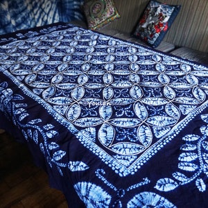 May include: A blue and white indigo dyed cotton tablecloth with a geometric pattern. The tablecloth has a border of leaves and vines.