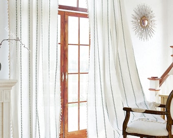May include: White curtains with a green chain-link pattern. The curtains are hanging in a window with a wooden frame. The curtains are flowing in the breeze.