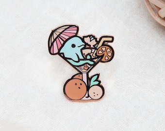 May include: A colorful enamel pin featuring a cartoon dolphin relaxing in a cocktail glass. The dolphin is light blue, with a pink and orange umbrella. The pin includes orange and cherry fruit accents.