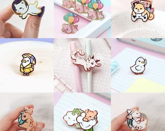 May include: A collection of enamel pins featuring various cute animal designs. The pins include a cat in a spacesuit, a pig with balloons, a dog playing video games, a duck wearing a raincoat, a squirrel, a pig in a cloud, and a dragon.