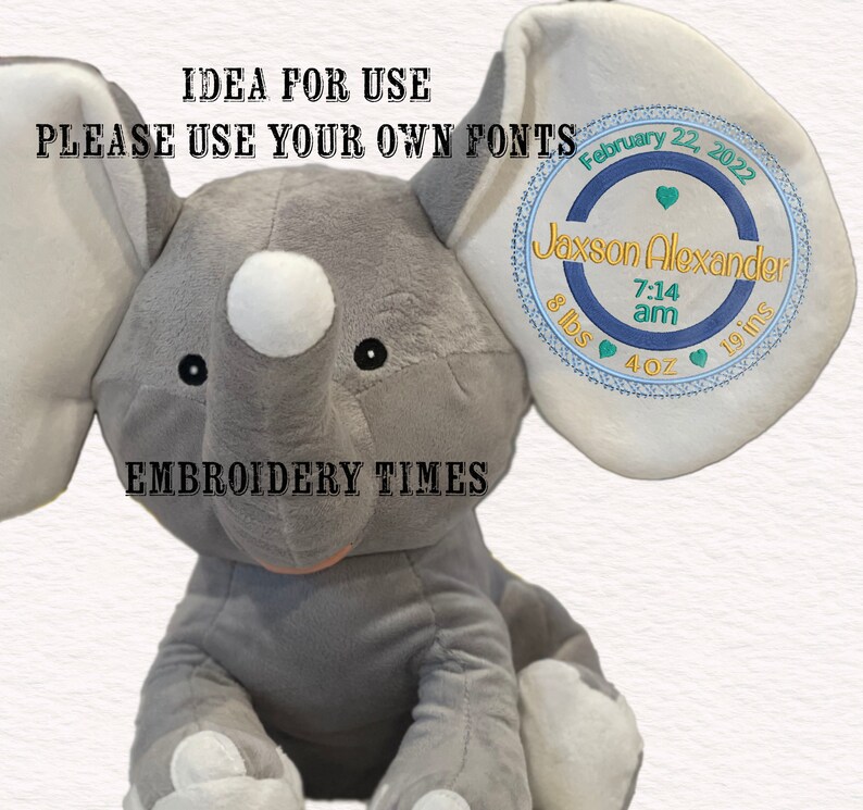 May include: Gray plush elephant toy with a white circle on its nose and black eyes. The elephant's ear has a blue and white embroidered circle with the text "Jaxson Alexander 7:14 am 8 lbs 4 oz 19 ins" and the date "February 22, 2022". The text "EMBROIDERY TIMES" is below the elephant.