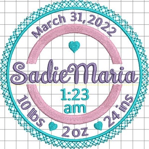May include: A turquoise blue circle with a white lace border. Inside the circle is a pink circle with a purple inscription that reads "Sadie Maria". The date "March 31, 2022" is written around the outer edge of the turquoise circle. The time "1:23 am" is written inside the pink circle. The weight "10 lbs 2 oz" and length "24 ins" are written around the bottom of the turquoise circle.