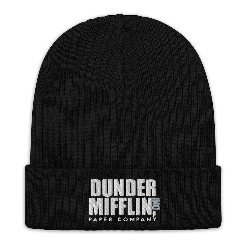 May include: Black knitted beanie with a white embroidered logo that reads "Dunder Mifflin, Inc. Paper Company"