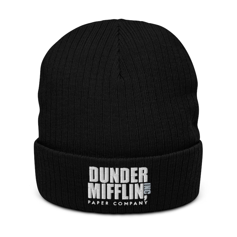 May include: Black knitted beanie with a white embroidered logo that reads "Dunder Mifflin, Inc. Paper Company"