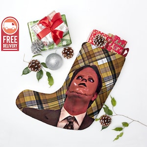 May include: A Christmas stocking with a plaid pattern and a face mask design. The face mask is red and has a stitched mouth and nose. The stocking is filled with wrapped gifts.