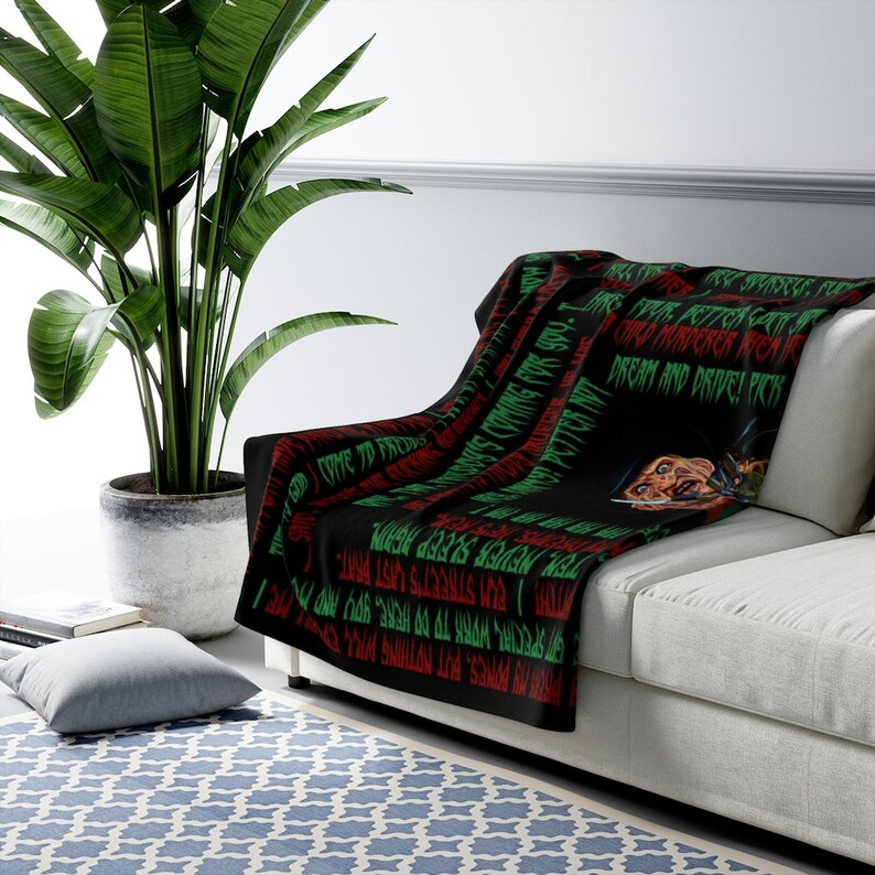 May include: Black and green throw blanket with a repeating pattern of text and a graphic of Freddy Krueger from the movie "A Nightmare on Elm Street". The text includes the phrases "Never Sleep Again", "Come to Freddy", "Dream and Drive", and "Reddy's Coming for You".