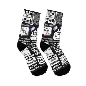 May include: A pair of black socks with a white print featuring text and images from the popular television show "The Office". The print includes quotes, characters, and scenes from the show. The socks are a fun and quirky way to show your love for the show.