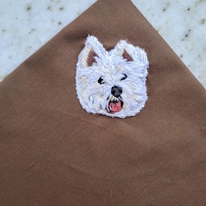 Brown pocket square with a hand-embroidered West Highland White Terrier face in white thread.