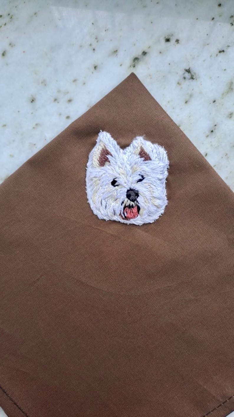 Brown pocket square with a hand-embroidered West Highland White Terrier face in white thread.