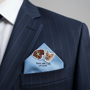 Navy pinstripe suit with a light blue pocket square embroidered with two dog portraits, their names and a wedding date.
