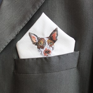 Personalized dog pocket square folded in a gray suit jacket pocket, with the embroidered pet portrait showing just above the pocket line.