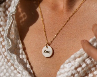 Chain necklace with a round porcelain pendant and the word love written in gold