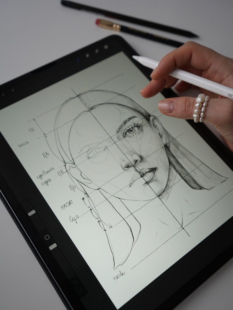 May include: A digital drawing of a woman's face on a tablet screen. The drawing is divided into sections with labels for the eyes, eyebrows, nose, lips, and neck.