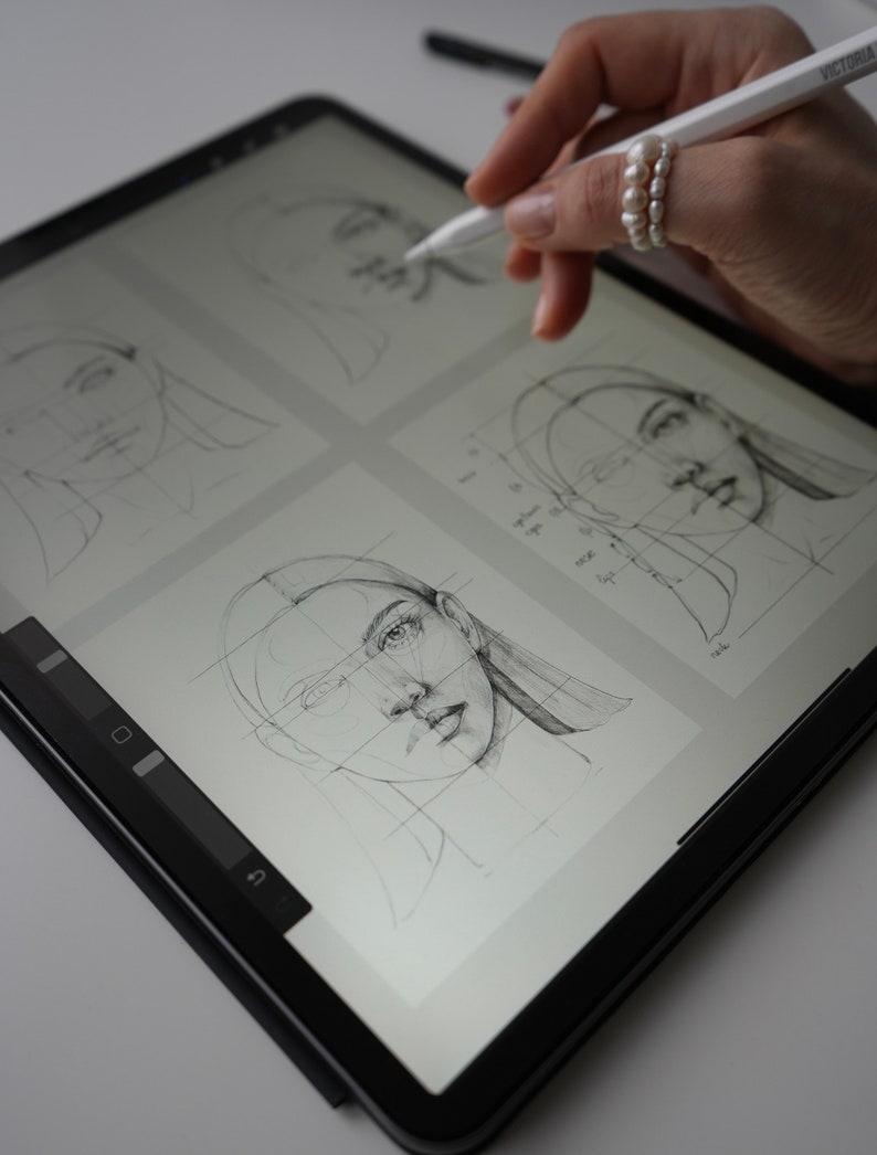 May include: A digital drawing tablet with a stylus, showing a gridded drawing of a face on the screen. The drawing is in progress, with lines and shading visible.