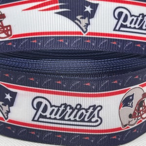 May include: A blue, white, and red ribbon with the New England Patriots logo and the word "Patriots" printed on it.