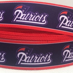 May include: Red, white, and blue ribbon with the word "Patriots" printed on it. The ribbon is made of a soft, woven fabric.