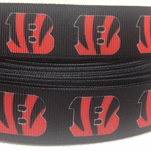 Cincinnati Bengals-inspirerat grosgrainband och/eller matchande 2,5 cm flatbacks. Perfekt för bågtillverkning och många andra hantverk. PRINT-B