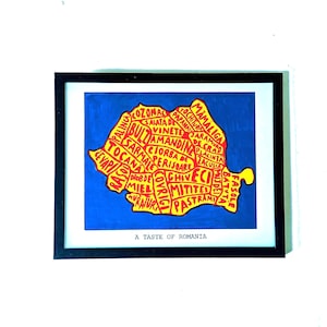 May include: A framed print featuring a yellow map of Romania divided into sections, each labelled with a traditional food name in red text. The map is set against a solid blue background. Below the map, the text A TASTE OF ROMANIA is printed.