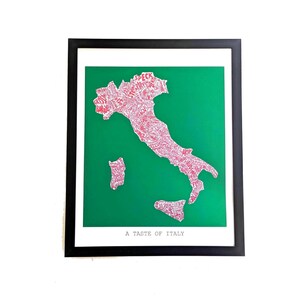 May include: A framed wall art print featuring a green background with a white map of Italy composed of red text. The map includes the islands of Sicily and Sardinia. The text A TASTE OF ITALY is printed in black at the bottom of the white border.