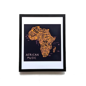 May include: Framed art print featuring a map of Africa in orange, filled with names, set against a dark blue background. The words "AFRICAN MUSIC" are printed in white at the bottom. The print is encased in a black frame.