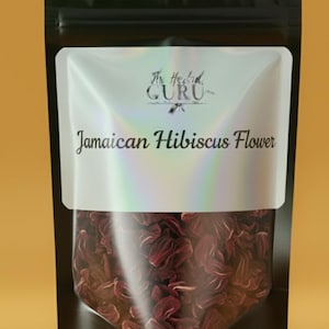 Könnte beinhalten: Ein schwarzer Standbeutel mit einem Sichtfenster, das getrocknete, dunkelrote jamaikanische Hibiskusblüten zeigt. Das weiße Etikett trägt den Text The Herbal GURU und Jamaican Hibiscus Flower in schwarzer Schrift mit holografischem Glanz.