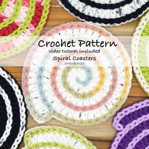 May include: Crochet pattern for spiral coasters, video tutorial included.  Five colorful coasters are shown on a wooden surface.  The coasters are made with different colored yarns, including black, white, green, purple, and pink.