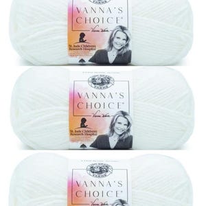 May include: Three skeins of white yarn with a pink and white label that reads "Vanna's Choice" with a signature from Vanna White. The label also includes the St. Jude Children's Research Hospital logo.