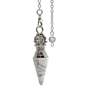 May include: A white and gray marble pendulum with a silver-colored metal top and chain. The pendulum has a conical shape and is suspended from a chain with a small bead at the end. The top has an ornate, decorative design.