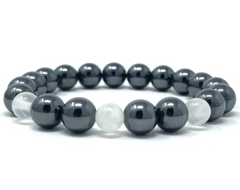 Puede incluir: Un brazalete de cuentas de hematites negro y piedra lunar blanca. El brazalete tiene cuentas negras y blancas alternas.