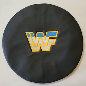 May include: Black leather car seat cover with a yellow, white, and blue embroidered "WF" logo.