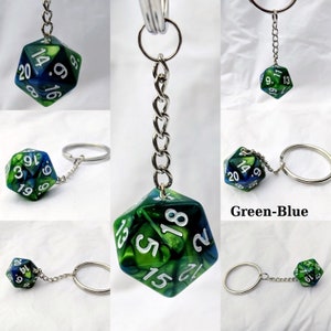 Puede incluir: Llavero de dados verde y azul con una cadena y un anillo plateados. El dado tiene n&uacute;meros blancos del 1 al 20.