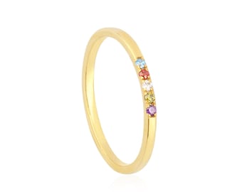 May include: A gold band ring with a row of colorful gemstones. The gemstones are set in a line along the top of the band.