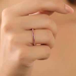 K&ouml;nnte beinhalten: Ein zarter Goldring mit einer Reihe kleiner rosafarbener Edelsteine.