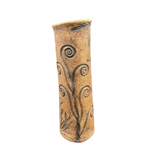 May include: A brown ceramic vase with a textured surface and a design of stylized leaves and swirls.